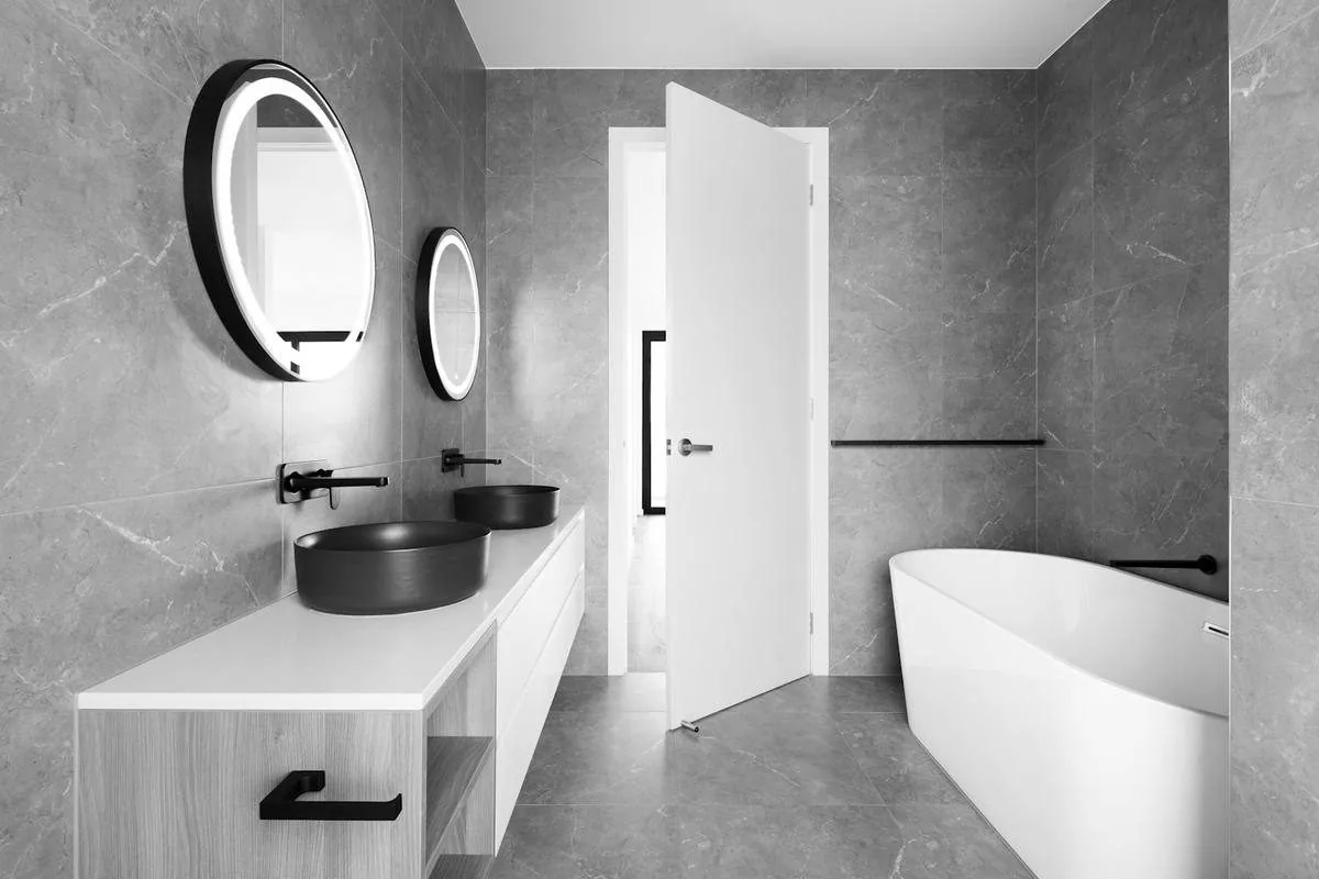 Badezimmer mit freistehender Wanne und zwei Lavabos